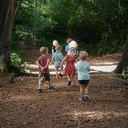 Kinderen van kinderdagverblijf Heppie Keppie spelen in het herfstbos